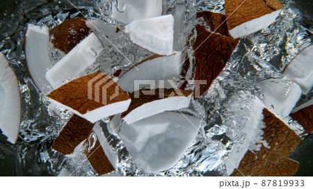 Fresh sliced coconuts falling into water Fresh sliced coconuts falling into water 87819933