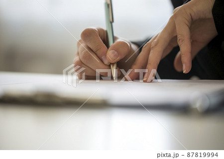 Hands of a person writing on a notepad 87819994