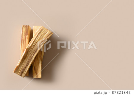 Three sticks of Palo Santo tree on a beige background. Minimal style. Ritual cleansing, meditation, aromatherapy. 87821342