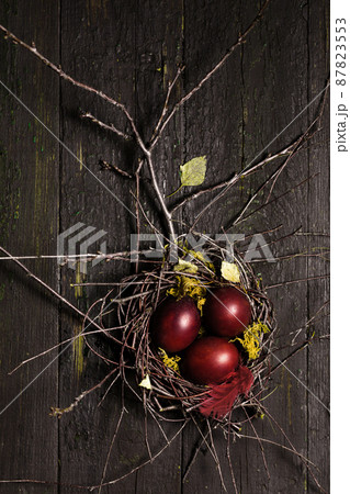 burgundy Easter eggs in a nest on wooden background burgundy Easter eggs in a nest on wooden background 87823553