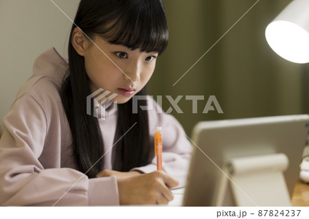 タブレットPCを見ながら勉強をする女の子 87824237