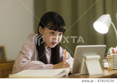 タブレットPCを見ながら勉強をする女の子 タブレットPCを見ながら勉強をする女の子 87824239