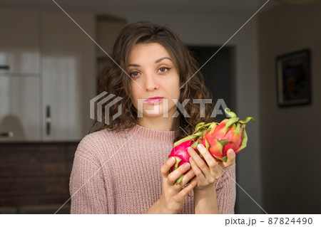 Young girl is holding two fresh ripe organic dragon fruits or pitaya, pitahaya. Exotic fruits, healthy eating concept 87824490