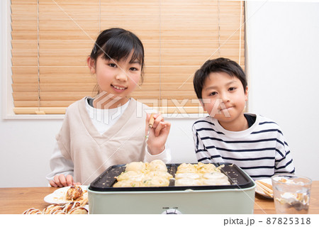自宅でたこ焼きを焼くアジア人の家族 87825318