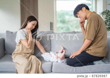赤ちゃんの世話をする男性と女性(困る) 赤ちゃんの世話をする男性と女性(困る) 87826987