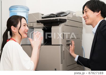 コピー機を直す男性と喜ぶ女性 87827169