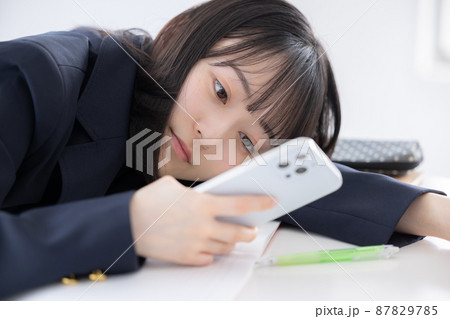 勉強に疲れてスマホを見る女子高生 87829785