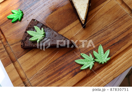Triangle shape browie with cannabis on wood plate. Triangle shape browie with cannabis on wood plate. 87830751