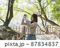 日本庭園を散策して写真を撮るカメラ女子 87834837