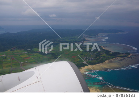 奄美大島 土盛海岸 離陸後の島の景色 機窓からの綺麗なサンゴ礁と海 奄美大島 土盛海岸 離陸後の島の景色 機窓からの綺麗なサンゴ礁と海 87836133