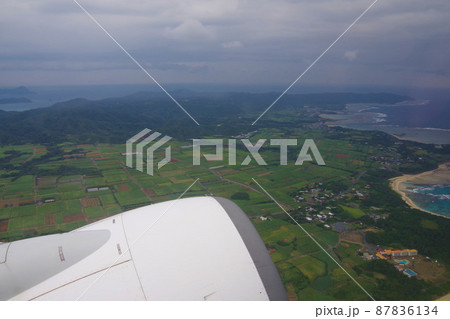 奄美大島 土盛海岸 離陸後の島の景色 機窓からの綺麗なサンゴ礁と海 奄美大島 土盛海岸 離陸後の島の景色 機窓からの綺麗なサンゴ礁と海 87836134
