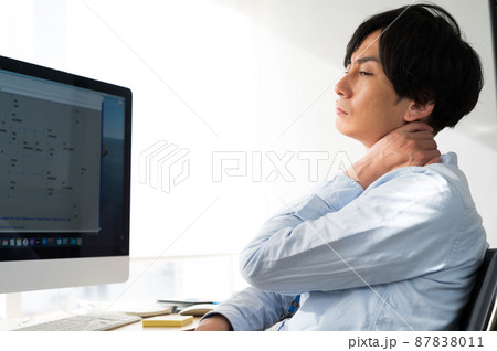 パソコンの前で疲れた表情の男性電気系エンジニア 87838011