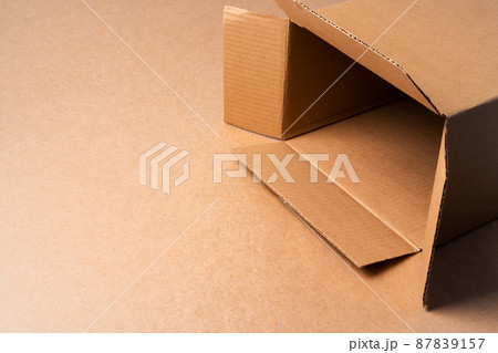 Cardboard box on beige background in studio 87839157