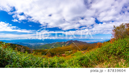 山腹から秋の山々と街並みを見渡す (蔵王温泉スキー場、山形県) 87839604