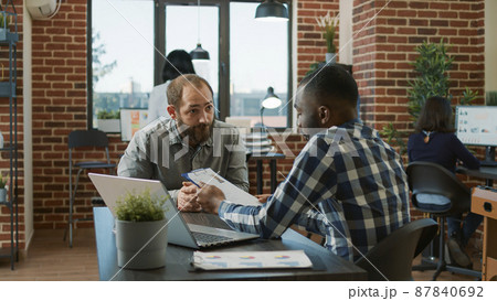 Diverse group of men attending job interview to discuss hiring and information about career recruitment. Candidate and employee having conversation about application at meeting. Diverse group of men attending job interview to discuss hiring and information about career recruitment. Candidate and employee having conversation about application at meeting. 87840692