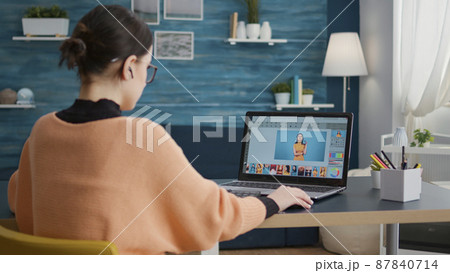 Photography student using retouching software to edit picture on laptop computer. Female editor using color grading to create multimedia design on photos, learning on online software. 87840714