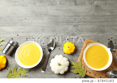 Concept of tasty food with pumpkin soup on gray textured table Concept of tasty food with pumpkin soup on gray textured table 87843163