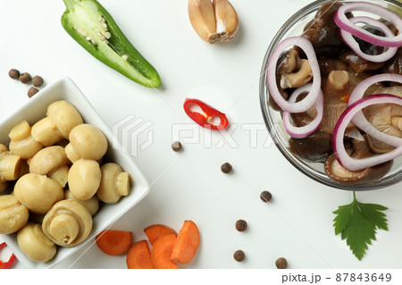 Bowls of marinated mushrooms on white background 87843649