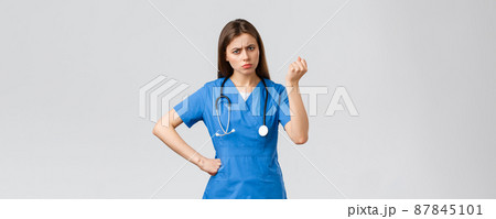 Medical workers, healthcare, covid-19 and vaccination concept. Angry and grumpy young female nurse, doctor scolding young patient breaking quarantine rules, shaking fist in threat Medical workers, healthcare, covid-19 and vaccination concept. Angry and grumpy young female nurse, doctor scolding young patient breaking quarantine rules, shaking fist in threat 87845101