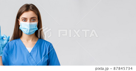 Covid-19, preventing virus, health, healthcare workers and quarantine concept. Confident female nurse or doctor working in clinic with coronavirus patients, in medical mask, show okay sign Covid-19, preventing virus, health, healthcare workers and quarantine concept. Confident female nurse or doctor working in clinic with coronavirus patients, in medical mask, show okay sign 87845734