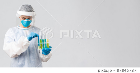 Covid-19, medical research, diagnosis, healthcare workers and quarantine concept. Doctor work clinical lab, test-tubes coronavirus vaccine samples, holding ampoules, wear personal protective suit Covid-19, medical research, diagnosis, healthcare workers and quarantine concept. Doctor work clinical lab, test-tubes coronavirus vaccine samples, holding ampoules, wear personal protective suit 87845737