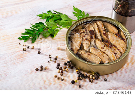 Tinned small smoked sardines on background with greens 87846143