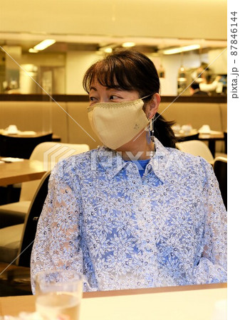 ホテルのレストランに座った手作りマスク姿の女性ツーリスト 87846144