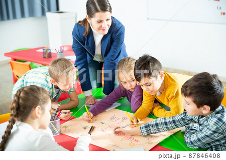 Kids and teacher playing educational board game Kids and teacher playing educational board game 87846408