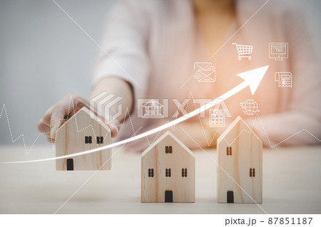 Businesswoman and mini wood house model and wood cubes of business from model on wood table, Planning buy Real Estate, Planning to buy property. Home insurance and security ideas concept. 87851187