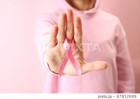 Young woman holds breast cancer awareness ribbon, close up Young woman holds breast cancer awareness ribbon, close up 87852699