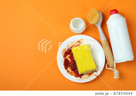 Concept of Dishwashing detergent accessories on orange background 87854044