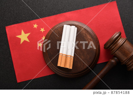 Cigarettes, wooden Judge gavel and flag of China. Smoking problem in China.Tobacco law. Tobacco control act 87854188