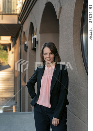 Smiling lady director wearing black suit. Business woman in jacket and trousers. Formal business clothing. Smiling lady director wearing black suit. Business woman in jacket and trousers. Formal business clothing. 87854491