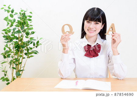 室内で勉強する女子高校生　QとAのアルファベットを持つ女性　疑問と答え 87854690