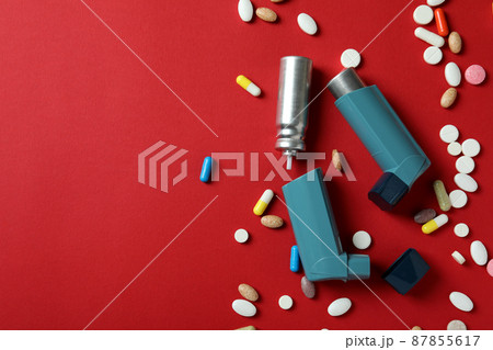 Asthma treatment accessories on red background, top view Asthma treatment accessories on red background, top view 87855617