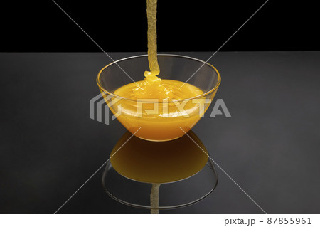 Fresh floral honey flows into a transparent plate in a mirror image. Organic Vitamin Health Food 87855961