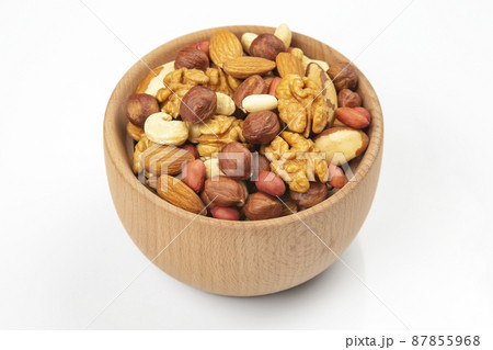 assortment of nuts in a wooden plate on a white background. vitamin organic food assortment of nuts in a wooden plate on a white background. vitamin organic food 87855968