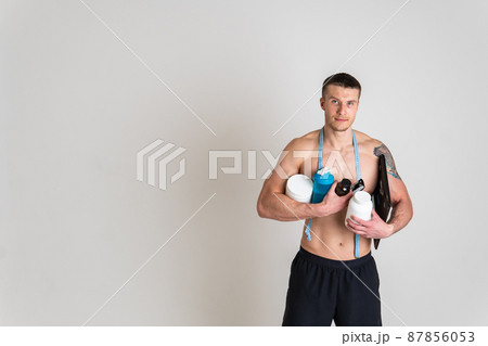 Fitness protein jars white on white background bodybuilder powder strong high back body person young adult, holding. Hold care, problem suffer attractive Fitness protein jars white on white background bodybuilder powder strong high back body person young adult, holding. Hold care, problem suffer attractive 87856053