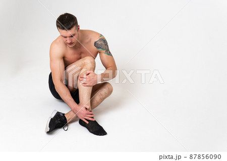 A man's kneecap hurts on a white background back sore man adult, hand chronic. Touching neck therapy, back suffer attractive A man's kneecap hurts on a white background back sore man adult, hand chronic. Touching neck therapy, back suffer attractive 87856090