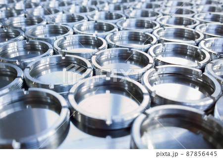 shiny metal rings after turning and milling, silver colored parts on flat steel surface close-up full frame background 87856445