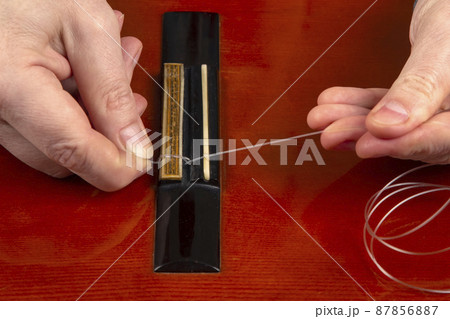 replacement and insertion of nylon strings in a classical guitar. lesson for a musician 87856887