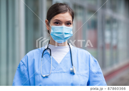 Young worried stressed anxious female EMS key worker doctor portrait outside hospital Young worried stressed anxious female EMS key worker doctor portrait outside hospital 87860366