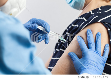 Nurse giving COVID-19 vaccine shot to elderly volunteer patient Nurse giving COVID-19 vaccine shot to elderly volunteer patient 87860379