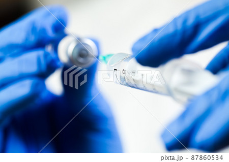 Medical syringe needle drawing vaccine shot from glass ampoule bottle Medical syringe needle drawing vaccine shot from glass ampoule bottle 87860534