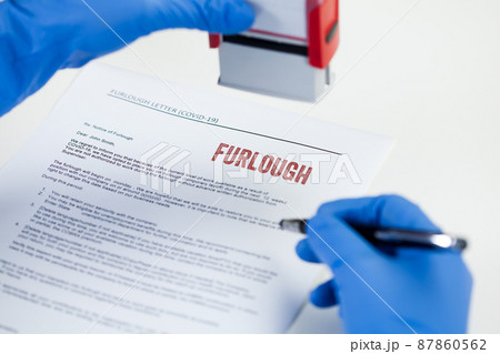 HR hand in blue protective glove stamping FURLOUGH notice letter 87860562