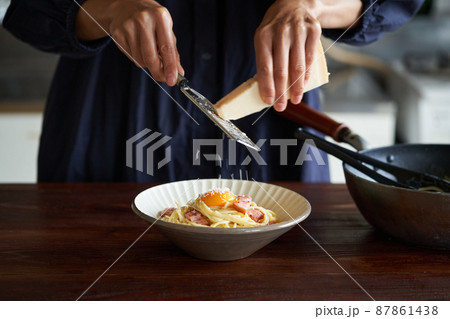 カルボナーラにパルミジャーノチーズをかける 87861438