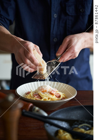 カルボナーラにパルミジャーノチーズをかける 87861442
