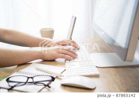 リモートワークで仕事中の男性の手元 87863142