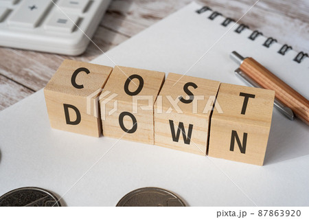 コストダウンのイメージ｜「COST DOWN」と書かれた積み木と筆記用具、電卓、コイン 87863920