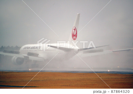 雨の日の飛行機　着陸 87864320